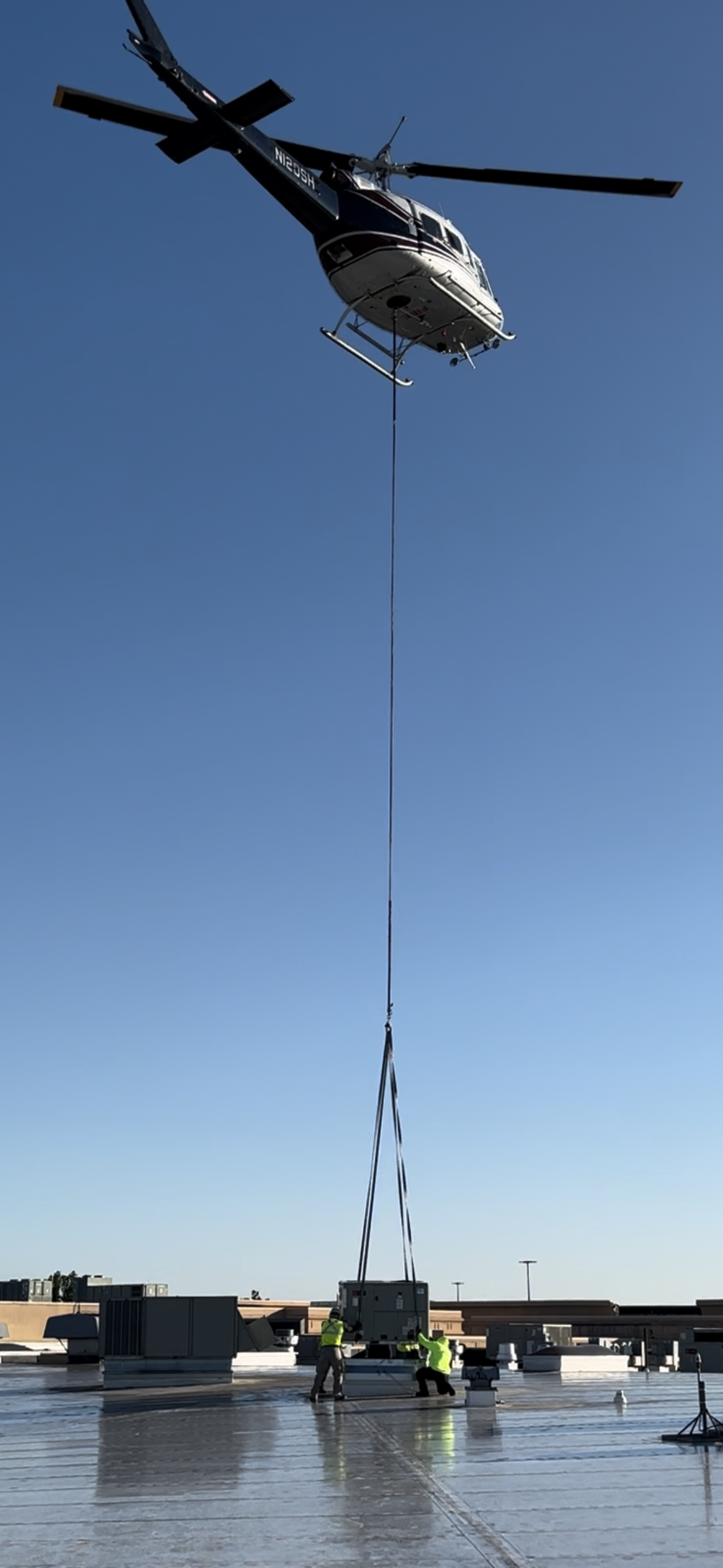 HVAC equipment lifted by helicopter onto a commercial rooftop