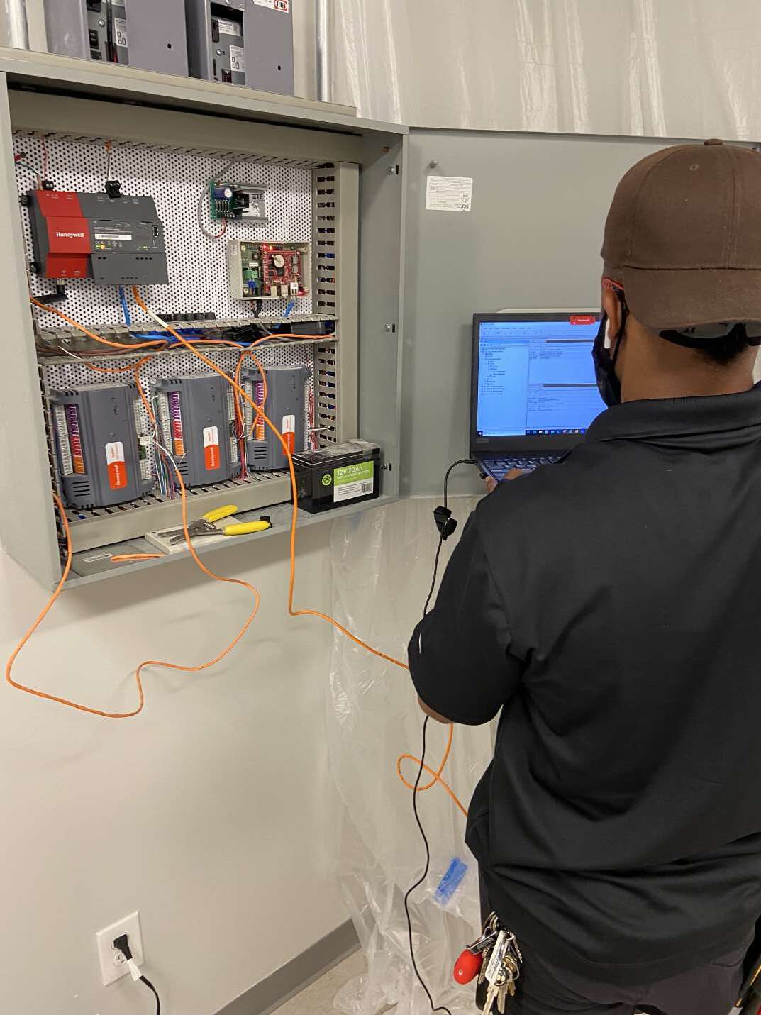 Technician testing an HVAC controls panel